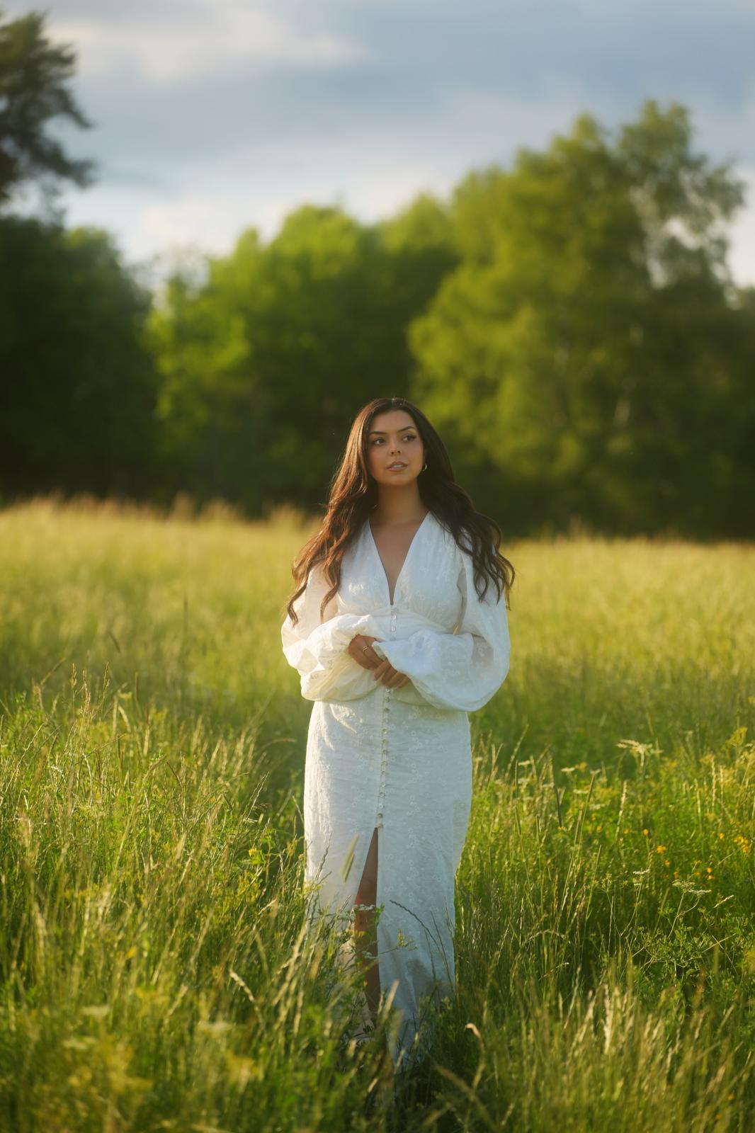 Victoria Grace standing in a sunlit Swedish meadow